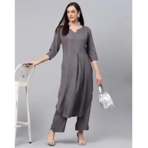 Woman wearing a solid grey long kurta with matching straight pants holding a silver handbag