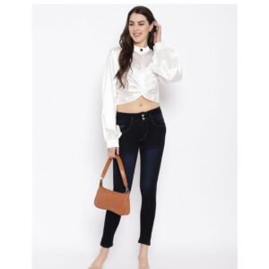 Woman wearing a white satin crop shirt with black skinny jeans holding a brown handbag